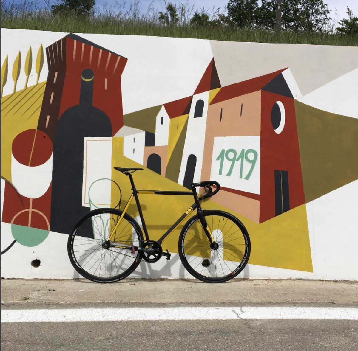 dësgenà fixed gear bike leaning against a painted wall
