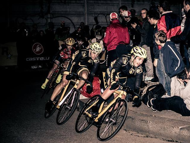 dësgenà riders racing at night in a criterium